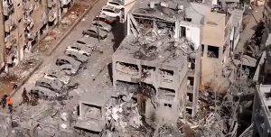 Imagens aéreas de um bairro urbano após ataques, com prédios destruídos, escombros e veículos danificados, em contexto de conflito entre Irã e Israel com mais de 200 mortos.