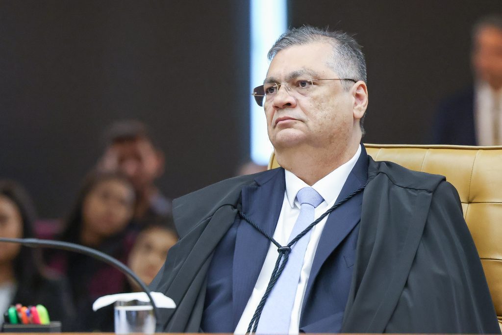 STF visto: Flávio Dino (STF) sentado em uma sessão, usando toga e gravata, em ambiente institucional do Supremo Tribunal Federal, em foto de destaque