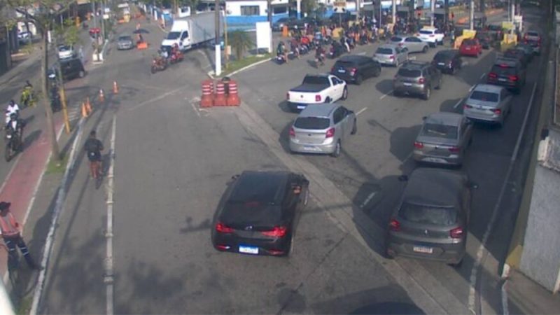 Balsa transportando veículos na travessia Santos-Guarujá, ilustrando o tempo de espera no litoral paulista.