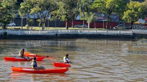 Mulheres praticando canoagem no Lago do Taboão durante o evento Remada da Mulher em Bragança Paulista.