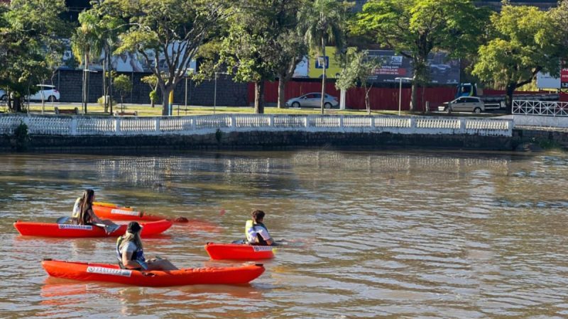 Mulheres praticando canoagem no Lago do Taboão durante o evento Remada da Mulher em Bragança Paulista.
