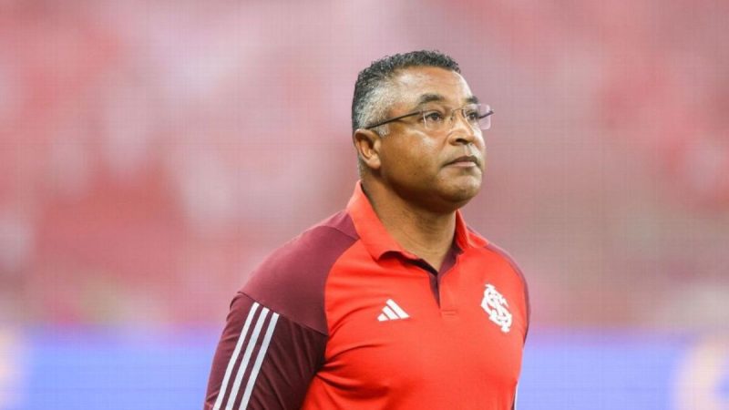 Roger Machado sorrindo com a camisa do São Paulo FC durante apresentação como novo técnico do clube.