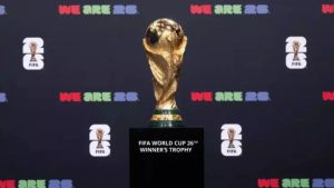 Estádio de futebol iluminado com as bandeiras dos países sedes da Copa do Mundo 2026: EUA, México e Canadá.