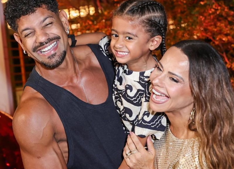 Viviane Araújo celebra 51 anos em festa luxuosa usando vestido dourado ao lado de bolo vermelho imponente.