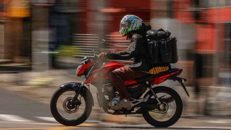 Motorista profissional segurando habilitação, representando o programa de CNH grátis em São Paulo.