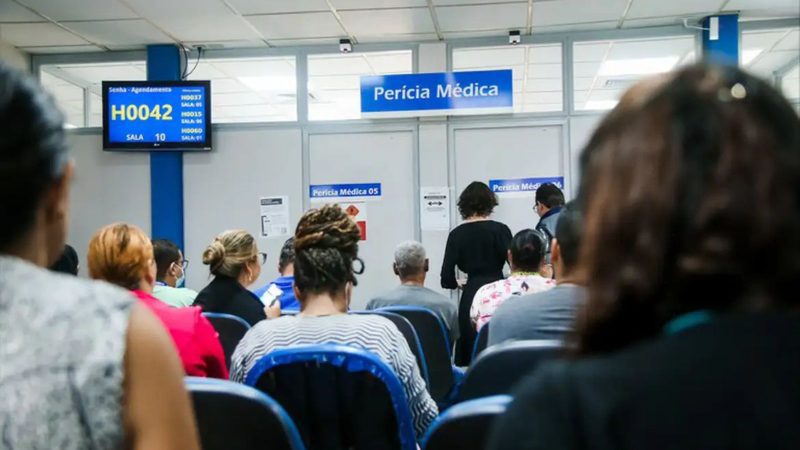 Médico perito realizando atendimento no mutirão de perícias médicas do INSS para redução da fila de espera.