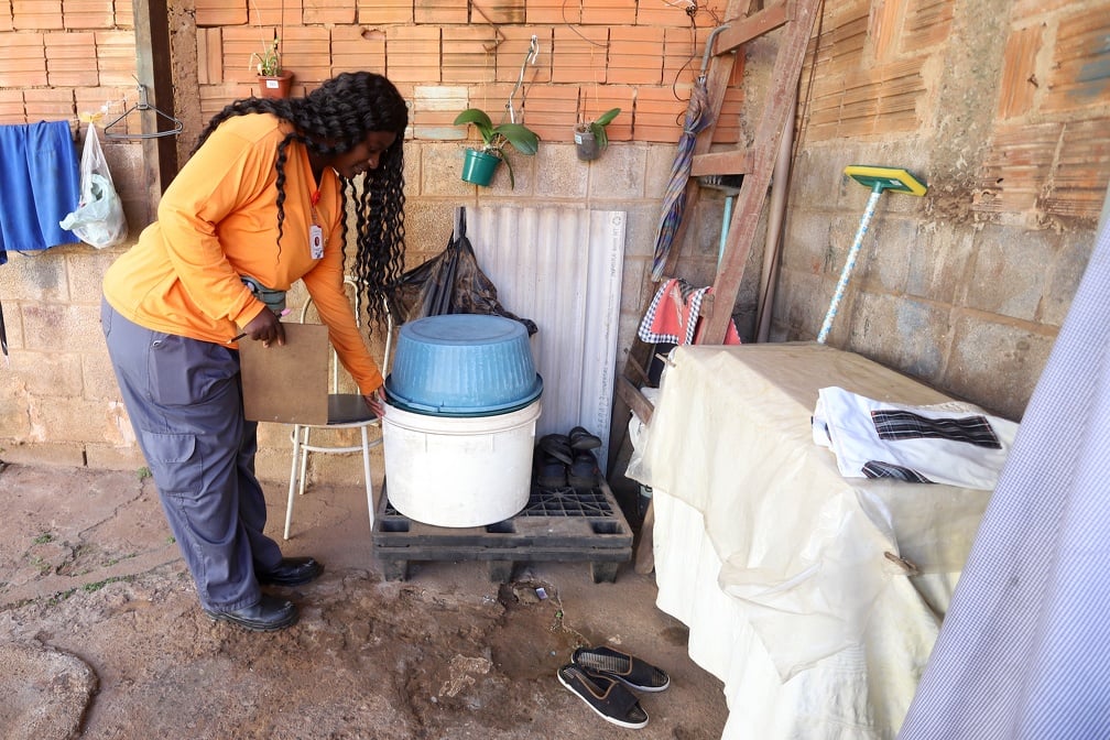 Médica agente de saúde em área doméstica recolhendo materiais e eliminando possíveis criadouros do mosquito, em ação de prevenção da transmissão de dengue em Campinas. Crédito Fernanda Sunega/Divulgação.