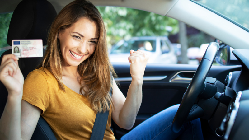 Carteira de habilitação CNH sobre volante de carro, representando a renovação automática para motoristas de Campinas.