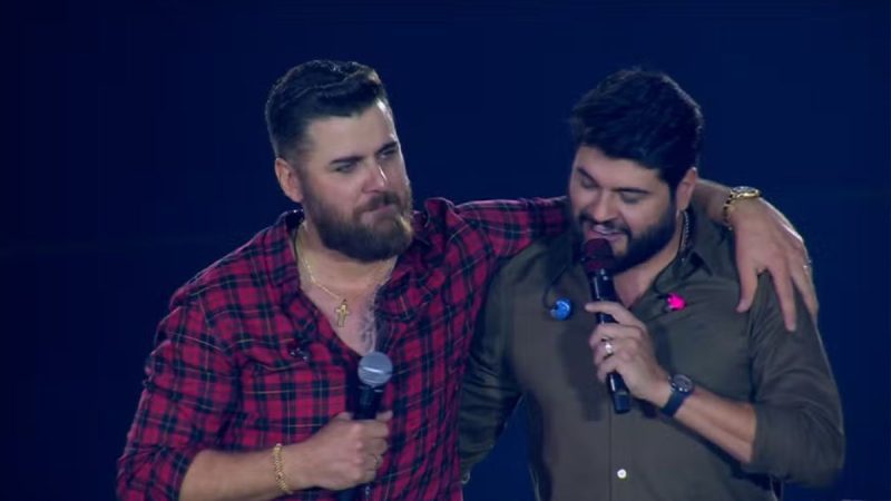 Dupla Zé Neto e Cristiano em destaque sobre decisão judicial de suspensão de vídeo por uso indevido de imagem.