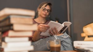 Pessoa lendo livro físico em momento de pausa e respiro durante o Dia Mundial do Livro.