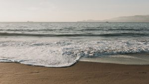 Vista de praia no litoral paulista com mar agitado, alertando para riscos de afogamento no feriado de Tiradentes.