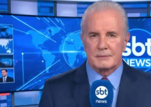 Apresentador Celso Freitas no estúdio do programa SBT News após recuperação de cirurgia de apendicite.