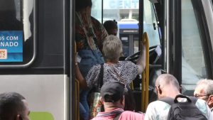Passageiro de ônibus com mancha de mostarda na roupa sendo abordado por criminosos no golpe da mostarda.