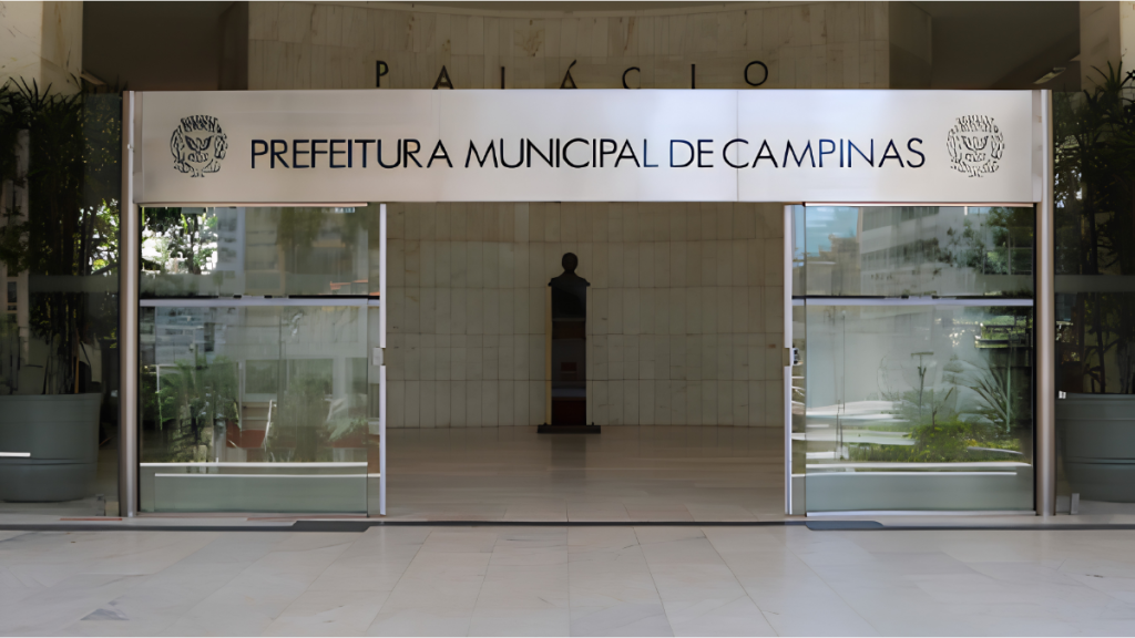 Entrada da Prefeitura Municipal de Campinas ao ar livre, com fachada onde aparece “Prefeitura Municipal de Campinas”. Imagem relacionada à lei sancionada pelo prefeito, com reajuste salarial e aumento de benefícios para servidores de Campinas.