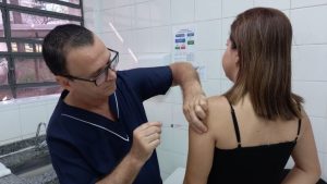 Profissional de saúde aplicando vacina da gripe em Valinhos para imunização de grupos prioritários.