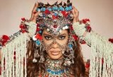 ensaios da anitta 2027: Anitta em ensaio com figurino carnavalesco elaborado, adornos e brilhos, em foto de alta produção para divulgação dos ensaios da artista em Jaguariúna.