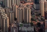 Vista aérea de um grande centro urbano com muitos prédios e ruas movimentadas, ilustrando a alta nos aluguéis residenciais em julho e como o custo pode subir na cidade.