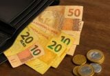 Notas de real e moedas simbolizando os R$ 10,55 bilhões de dinheiro esquecido em contas bancárias por clientes.