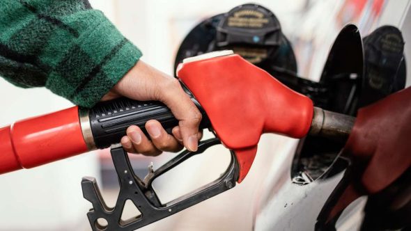 Imagem com bomba de combustível e mangueira vermelha abastecendo veículo, ilustrando notícia sobre Lula zera impostos do diesel e cria subvenção para conter a alta do combustível.