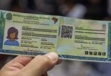 Carteira de Identidade Nacional (CIN) sendo exibida em close, com foto, dados pessoais e QR code no documento. Entenda como emitir a CIN no Poupatempo em SP.