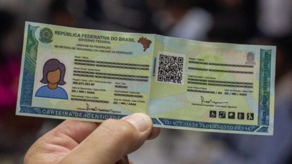 Carteira de Identidade Nacional (CIN) sendo exibida em close, com foto, dados pessoais e QR code no documento. Entenda como emitir a CIN no Poupatempo em SP.