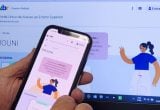 Celular em mãos acessando o portal com a página do Prouni e cronograma, com ilustrações educativas na tela do computador; informação sobre Prouni 2026 lista de espera.