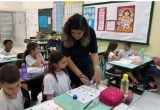 Professor explicando para aluno em escola de Santos